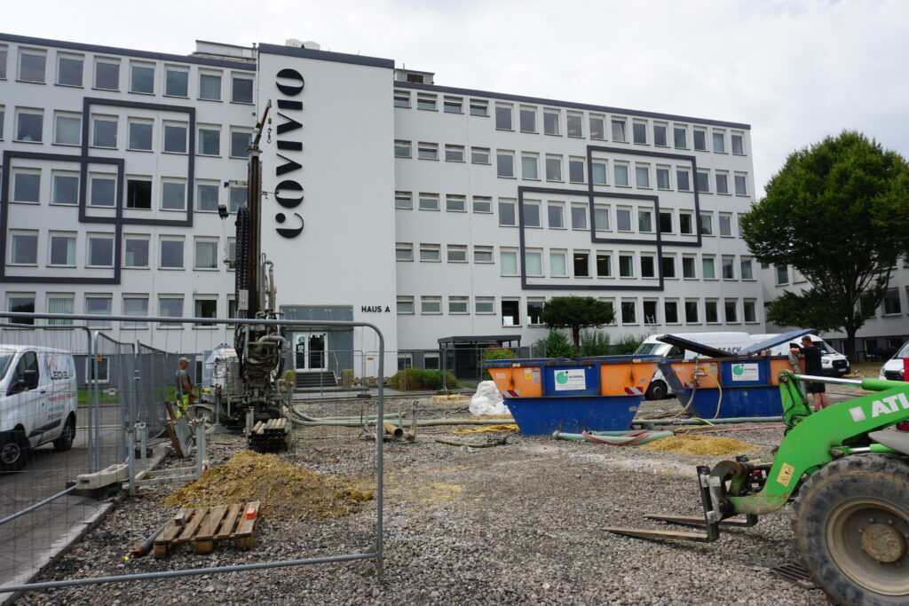 Covivio Gebäude mit Bohrgerät, Radlader und Container im Vordergrund